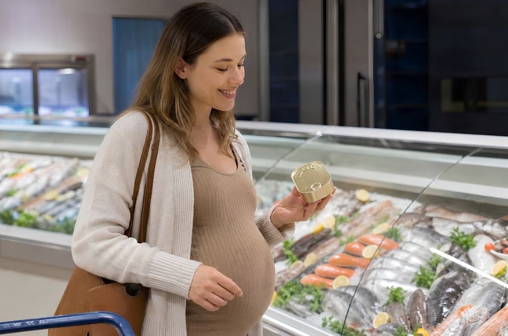 Femme enceinte faisant ses courses au rayon poissonnerie et choisissant des sardines en conserve