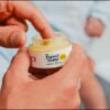 Doigt prélevant du baume visage Pototam dans son pot ouvert Doigt prélevant du baume visage Pototam dans son pot ouvert