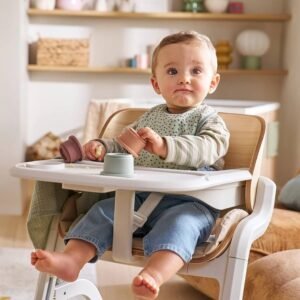 Bébé assis dans la chaise haute évolutive Woodynest Vertbaudet, avec babyset et tablette, dans une pièce de vie
