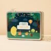 Boîte en métal du coffret Merveilles Pototam, illustrée d’un feu de camp en forêt Boîte en métal du coffret Merveilles Pototam, illustrée d’un feu de camp en forêt