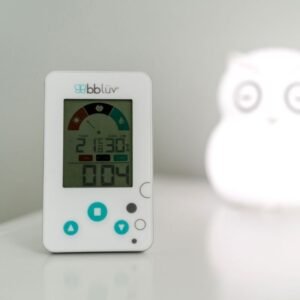 Thermomètre hygromètre BBLUV posé sur un meuble blanc, à côté d'une veilleuse en forme de hibou