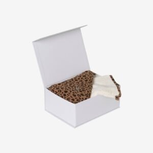 Coffret cadeau blanc ouvert, contenant une cape de bain pliée à motif léopard