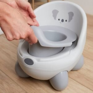 Main soulevant le réducteur d'un pot de bébé gris et blanc orné d'un koala