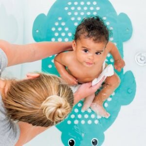 Bébé allongé sur un tapis de bain antidérapant en forme de tortue, tenu par un adulte