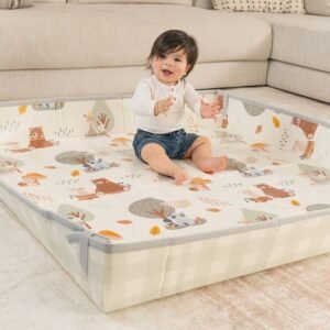 Enfant assis au centre d'un grand tapis de mousse pliable à motifs animaux, dans un salon